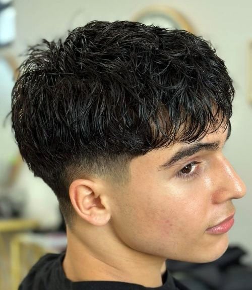 The fluffy fringe with a low taper fade is a neat, gentlemanly style emphasizing texture despite