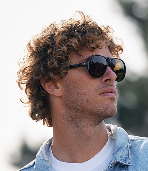 A medium-length, messy curly hairstyle is a stylish look that signals individuality