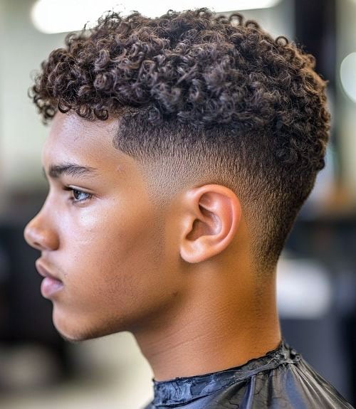 Short curly hair with a low burst fade is a clean-cut, dapper style that showcases tight