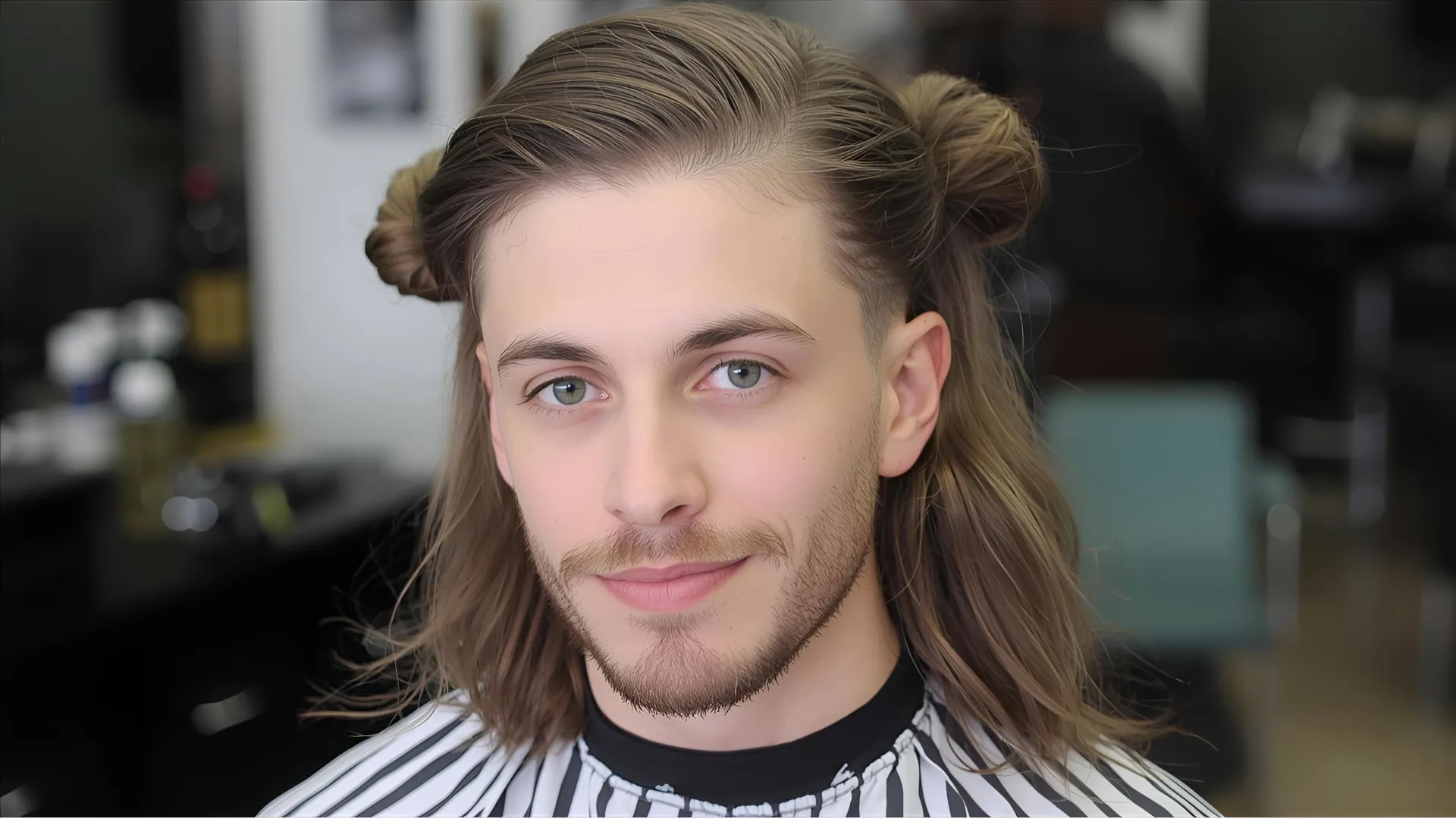 Long Hair Low Taper Fade styled in flowy layers, showing clean taper on sides and back with top tied in a loose man bun — modern 2025 men’s hairstyle.